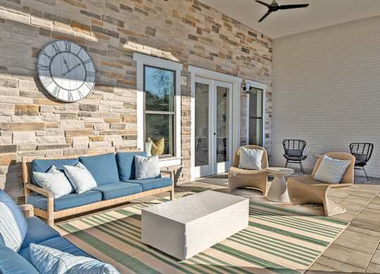 A living room with a blue couch and a stone wall.