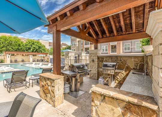 A patio with a grill and a pool table.