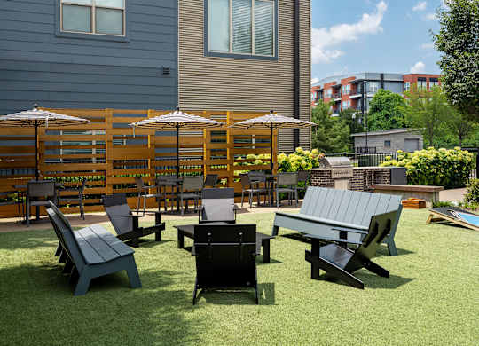 A set of outdoor furniture including chairs and tables are arranged on a lawn.