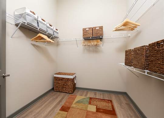 A room with a rug and baskets on the floor.