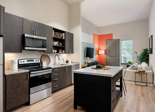 A modern kitchen with dark wood cabinets and stainless steel appliances.