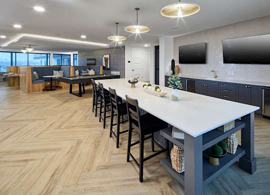 A modern kitchen with a long table and chairs.