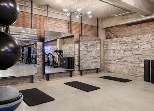 the gym has a stone wall and rugs on the floor