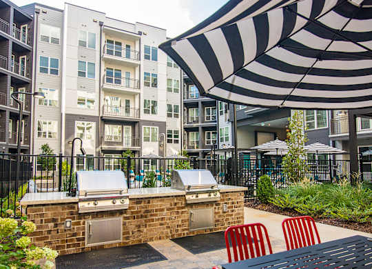 our apartments have a large outdoor patio with a grill and an umbrella