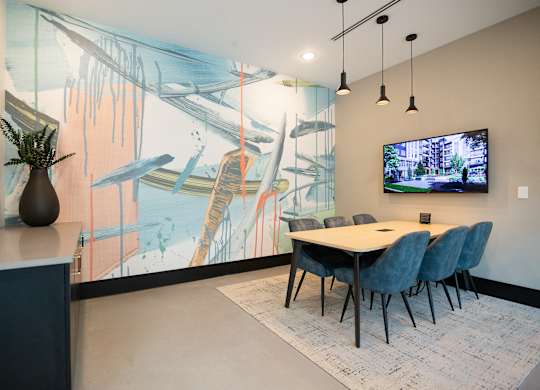 a dining room with a table and chairs and a tv on the wall