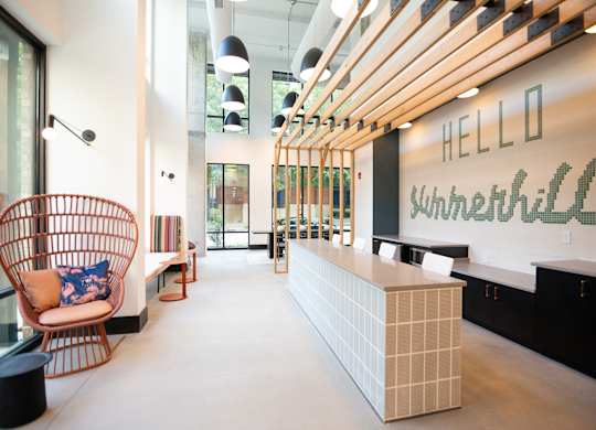 a reception area with a chair and a counter and a sign on the wall
