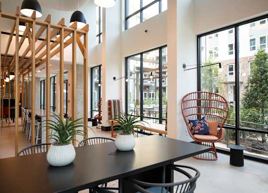 a dining room with a table and chairs and large windows