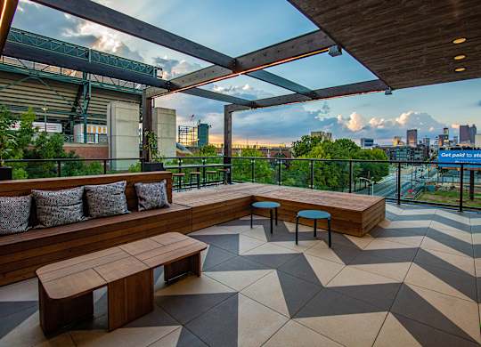 a rooftop terrace with benches and a view of the city