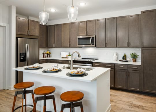 a kitchen with a large island with three stools