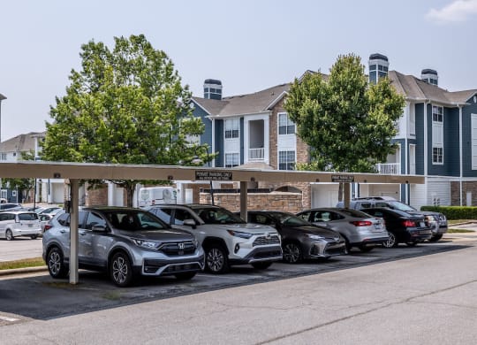 a row of cars parked in a parking lot in front of a building