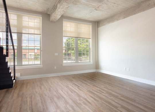 an empty living room with white walls and wood floors