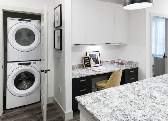 a washer and dryer in a kitchen with a counter top and a sink