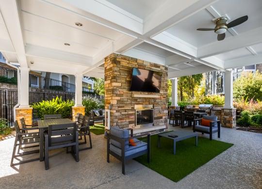 a patio with a stone fireplace and tables and chairs