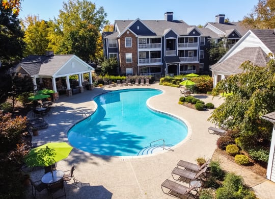 an aerial view of a swimming pool with an apartment building in the background