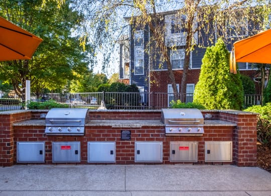 a brick barbecue with four ovens on it in front of a house