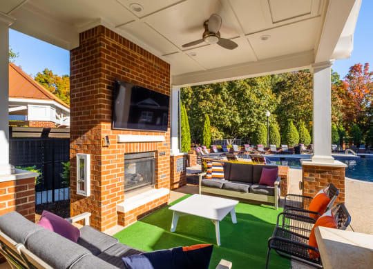 a backyard with a fireplace and a pool with lounge chairs and a table