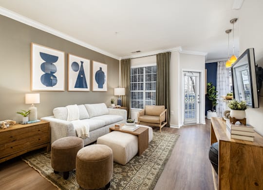 A living room with a white couch, a wooden dresser, and a rug.