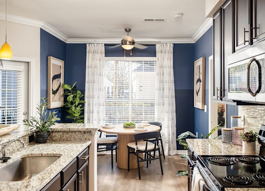 A kitchen with a table and chairs in the middle of the room.