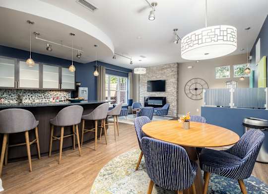A modern kitchen with a bar area and a dining table set up.