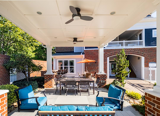 a patio with a table and chairs and a ceiling fan