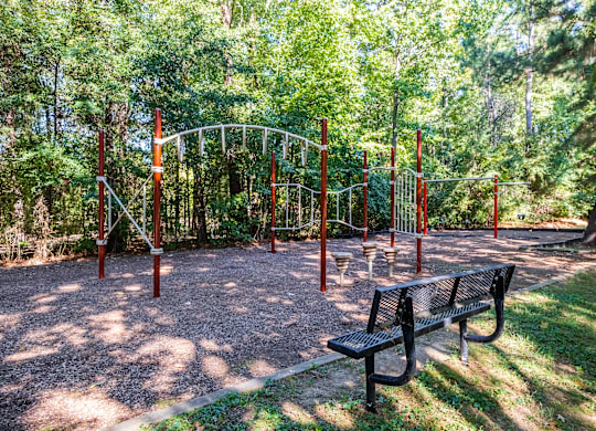 a playground with a swing set and a bench