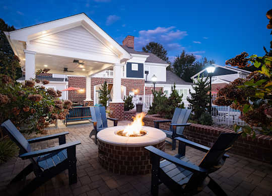 A backyard with a fire pit and chairs.