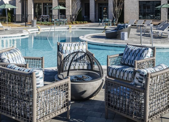 a pool with chairs and a house in the background