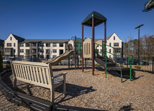 a playground with a slide and a bench in a park