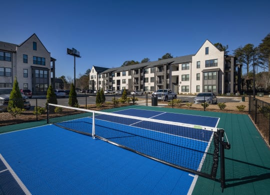 two tennis courts with apartments in the background