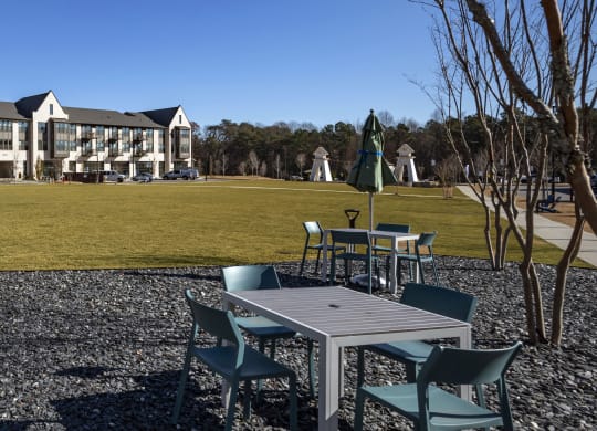 a park with tables and chairs in front of a building