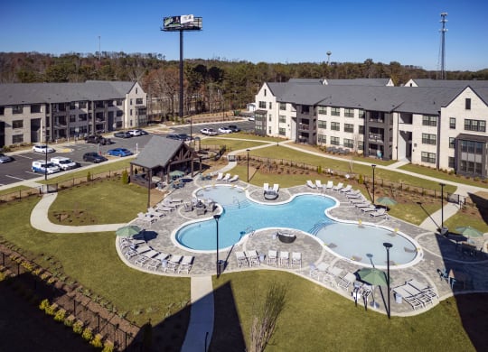 an aerial view of an apartment complex with an outdoor swimming pool