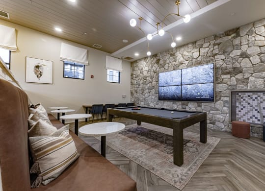 a billiards table in a clubhouse with a stone wall