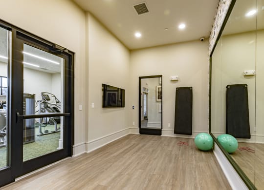 a fitness room with mirrors and balls on the floor