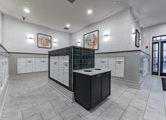 a locker room with white cabinets and counters and a black counter top in the center