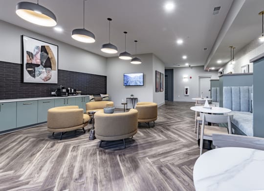 a lounge area with chairs and tables and a television
