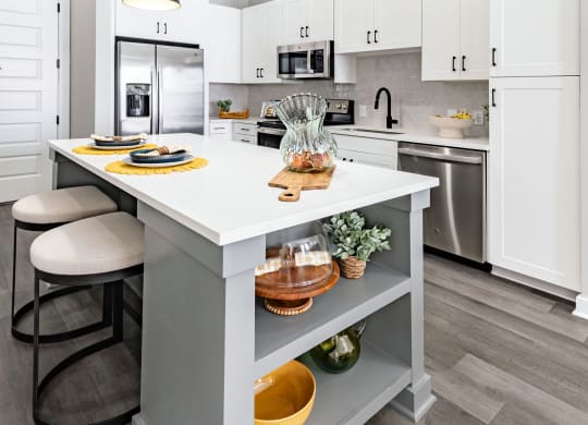 an open kitchen with a large island with two stools