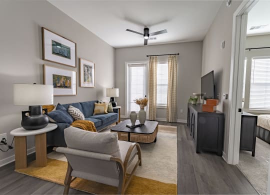 our apartments offer a spacious living room with a couch and a tv