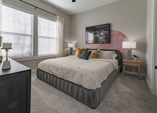 a bedroom with a bed and two windows