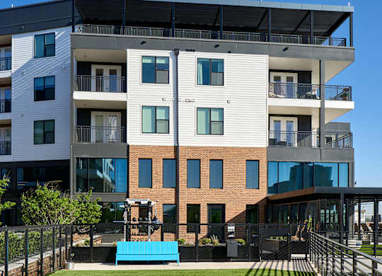 A modern apartment building with a green lawn in front.