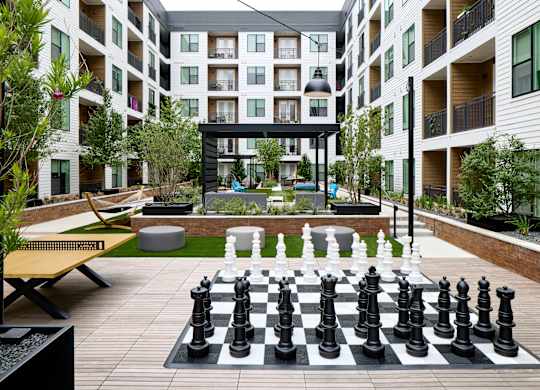 A giant chess board is in the middle of a courtyard.