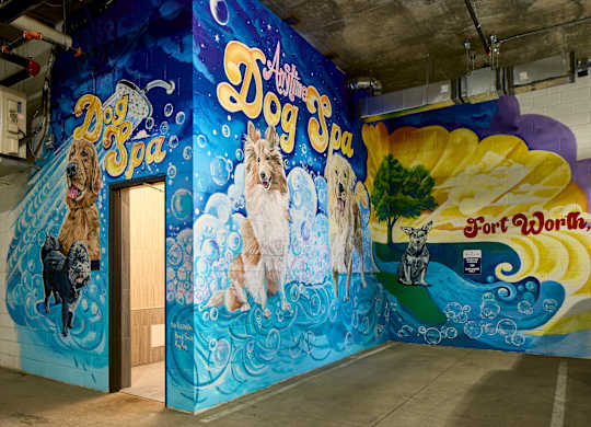 A mural of dogs painted on a wall in a room.