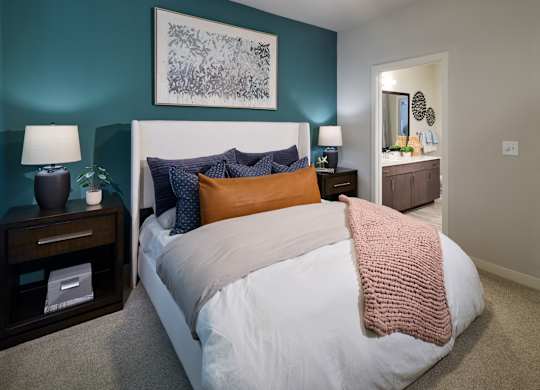 A bedroom with a white bed and a pink blanket.