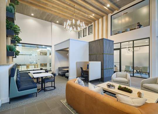 A modern living room with a brown sofa and a wooden ceiling.