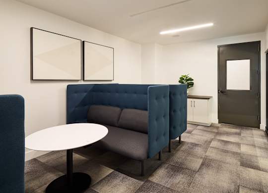 A modern office space with a blue sofa and a white table.