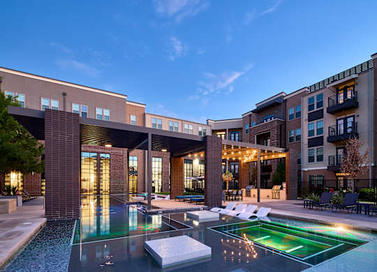 A modern building with a pool in front.