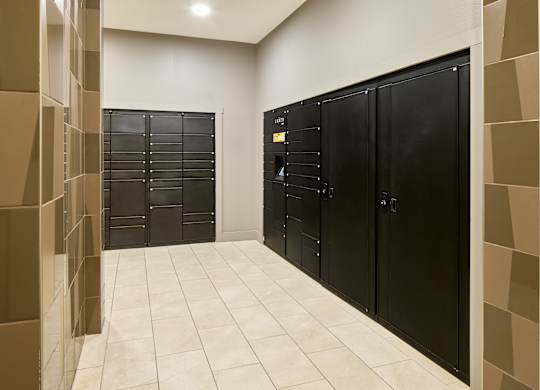 A hallway with black doors and a tiled floor.