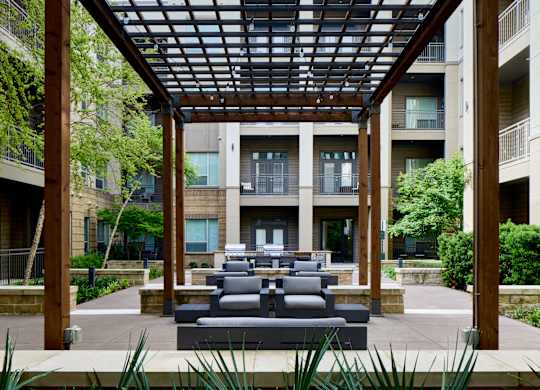 A patio with a couch and a table under a roof.