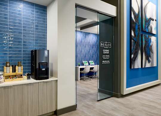A room with a blue wall and a black fridge.