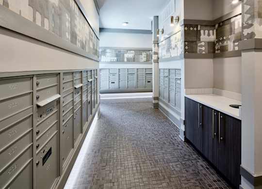 A long hallway with a row of mailboxes on the left and a row of cabinets on the right.