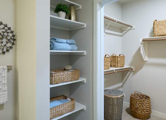 A white closet with shelves and baskets.